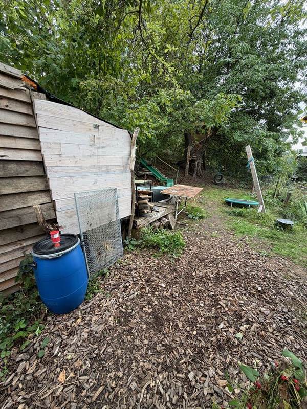 Gartenhütte mit Holzweg zu Trampolin und Baumhaus