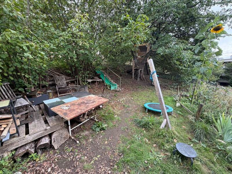 Sitzplatz mit Trampolin und Baumhaus im Garten